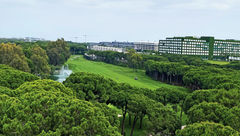 The Montgomerie Maxx Royal course appears as green carpet carved through umbrella pines.