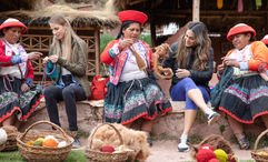 Members of the Ccaccaccollo Women’s Weaving Co-op interact with travelers in Peru's Sacred Valley.